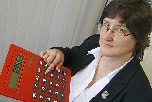 image of a brown haired woman with glasses holding a silly oversized calculator